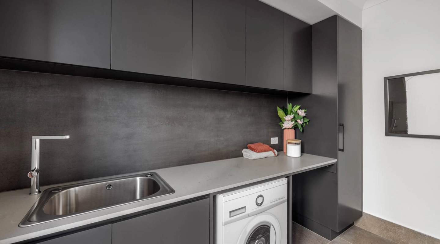 matte black laundry splash back with neutral flooring to brighten up the space at berwick 38